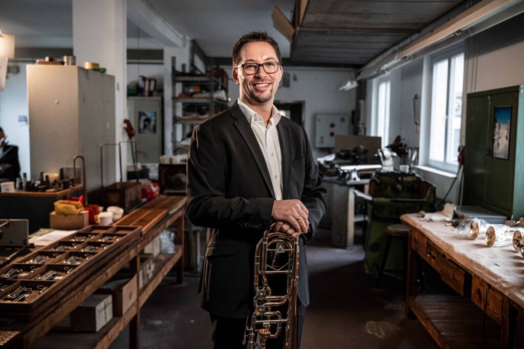 Fabian Kerber Posaunist im Kühnl Trombone Quartet mit Posaune in der Werkstatt der Blechblasinstrumentenfirma Kühnl & Hoyer
